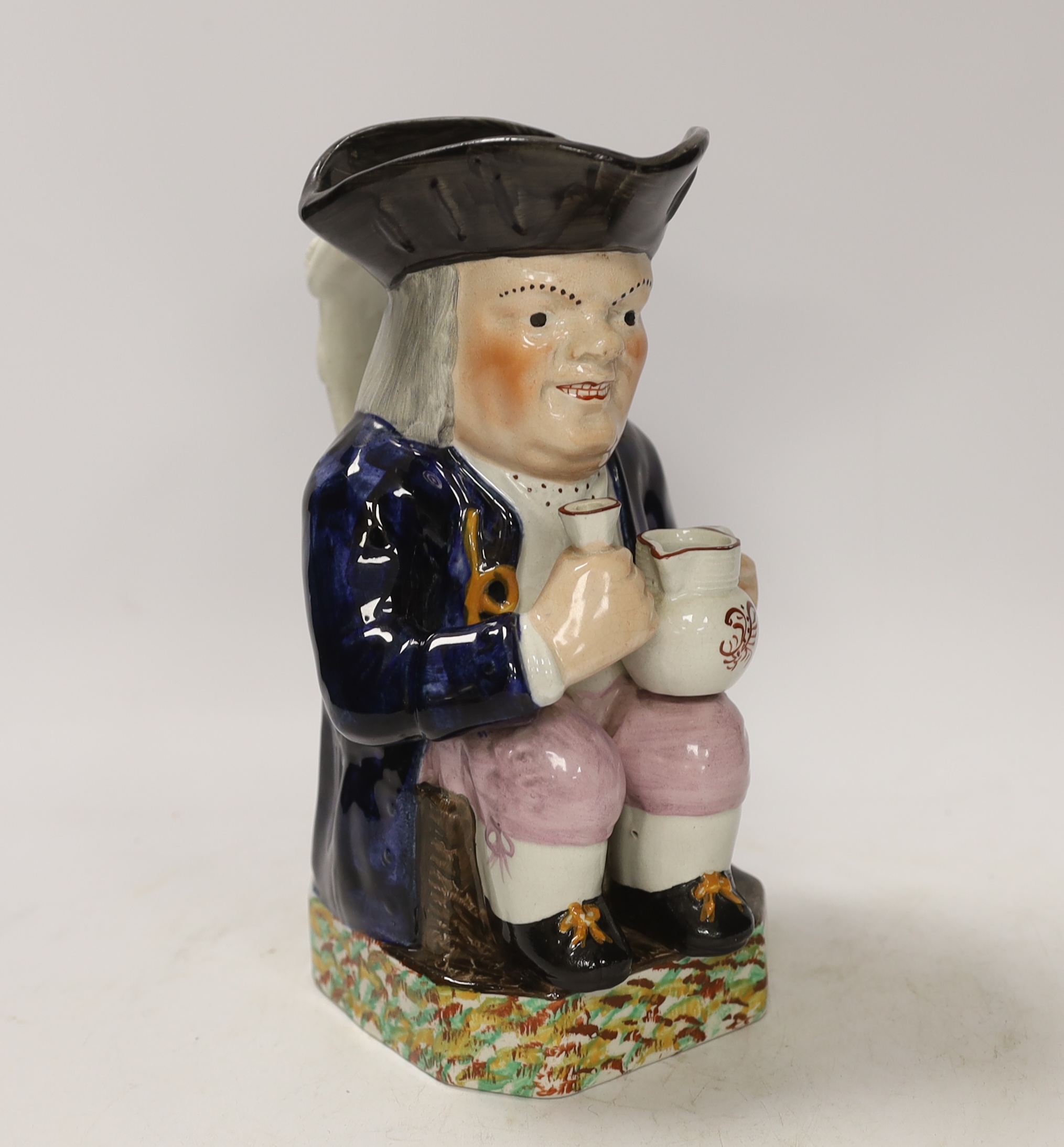 A Mexborough Toby jug, modelled holding a jug and a beaker, caryatid figural handle, black hat and sponge decorated base, 25cm high. Condition - fair